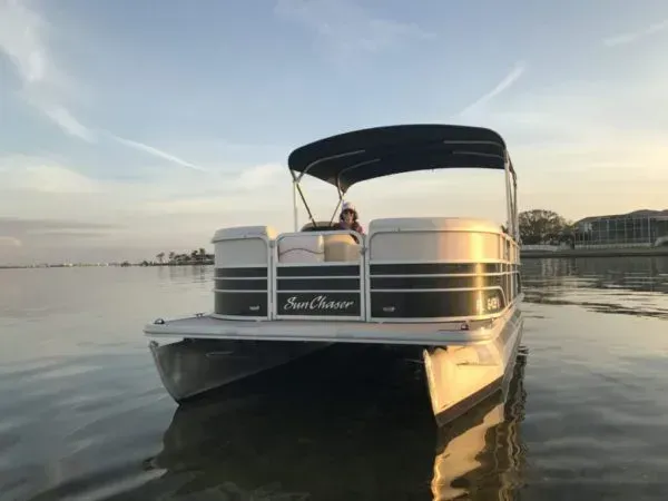A pontoon boat is floating on top of a body of water.