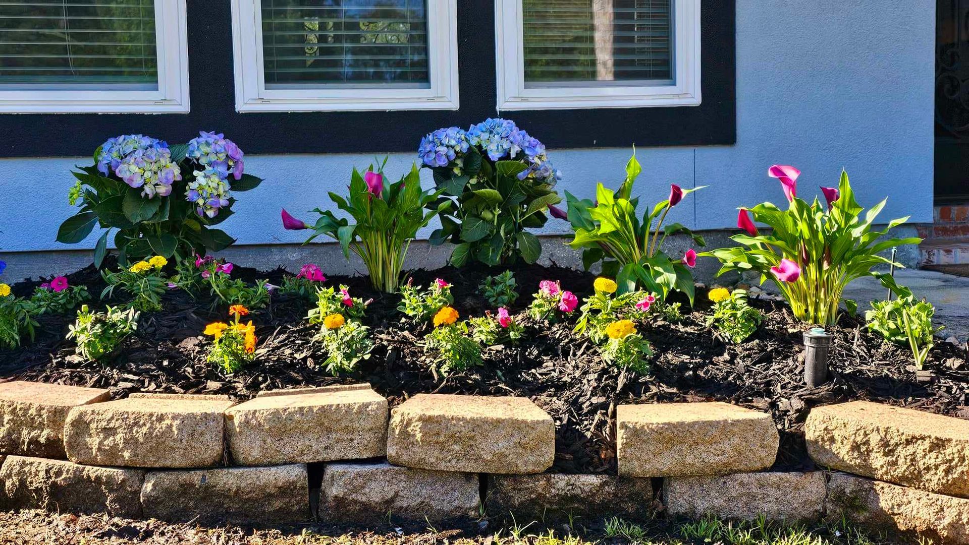 A brick wall with flowers in front of a house