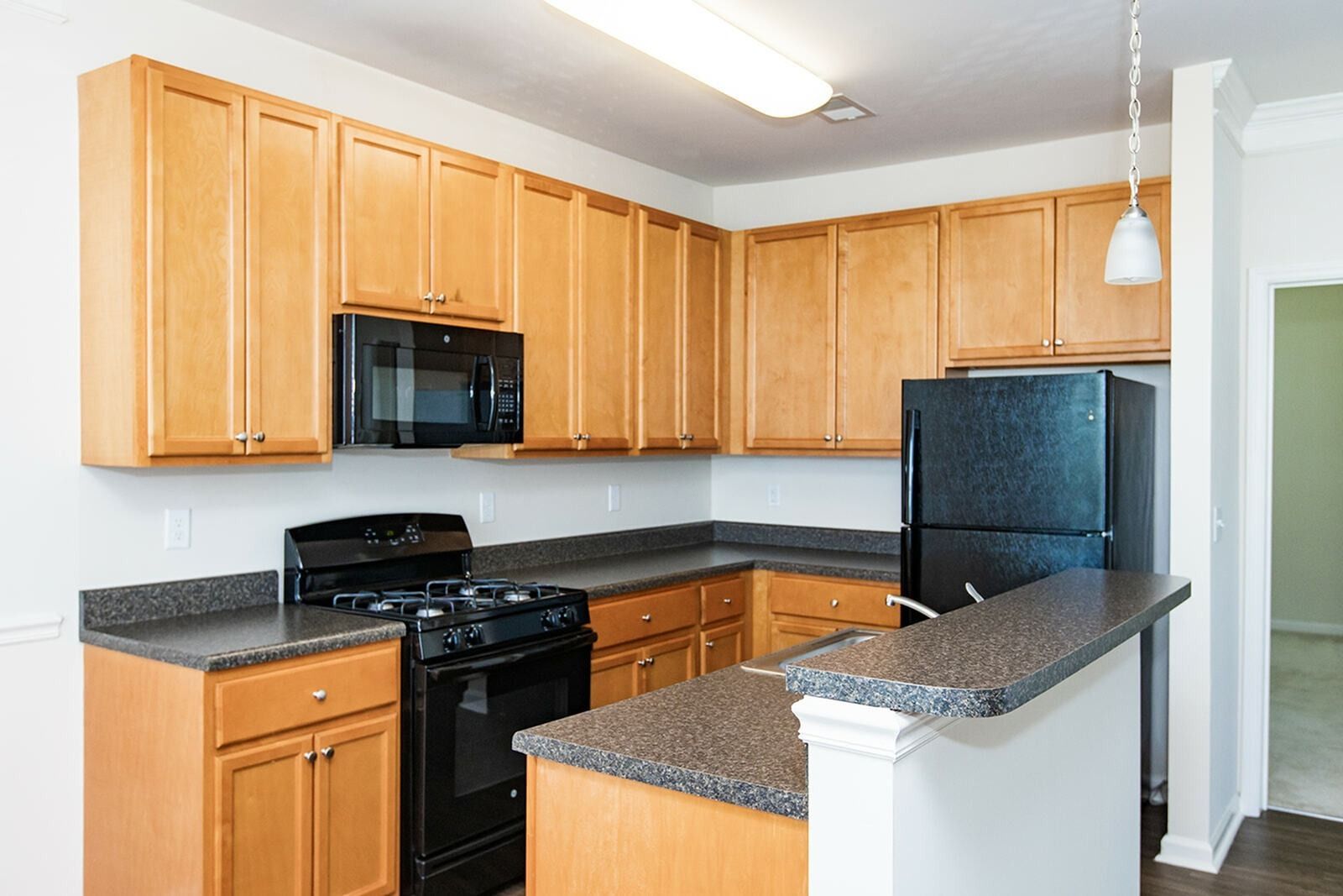 The Reserve at Stoney Creek apartment kitchen with cabinets, black appliances, and plenty of countertop space. 