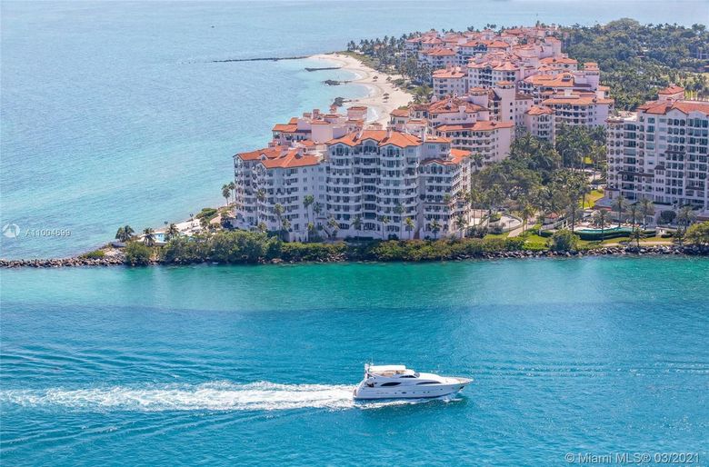 Luxurious hotel lobby with marble floors, neutral furniture, and central artwork.