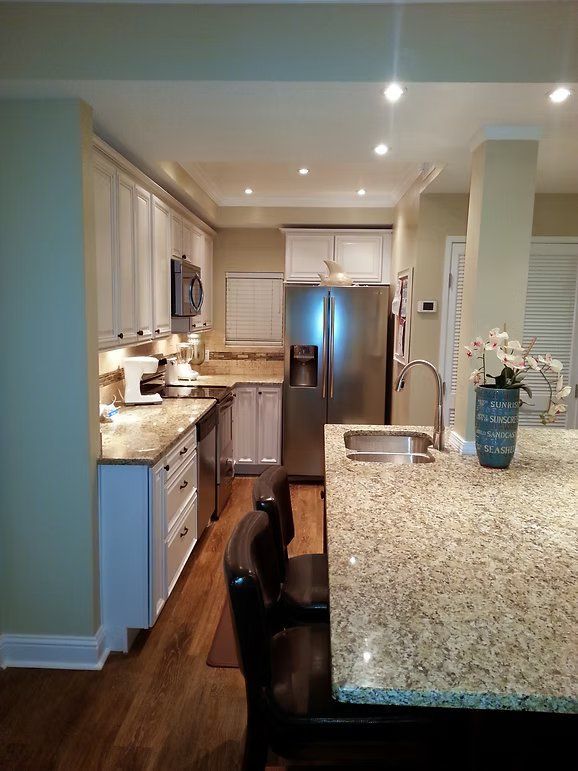 Kitchen with white cabinets, stainless steel appliances, and granite countertops.