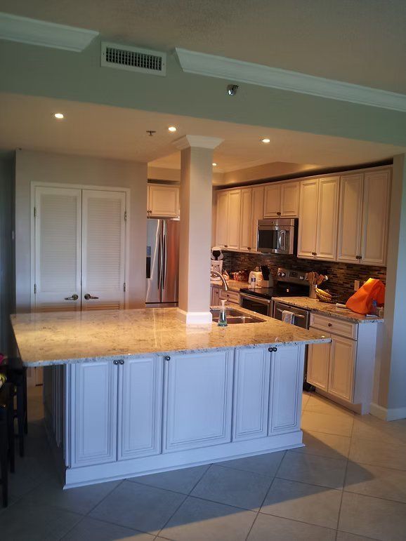 Kitchen with light gray cabinets, granite countertops, and island.
