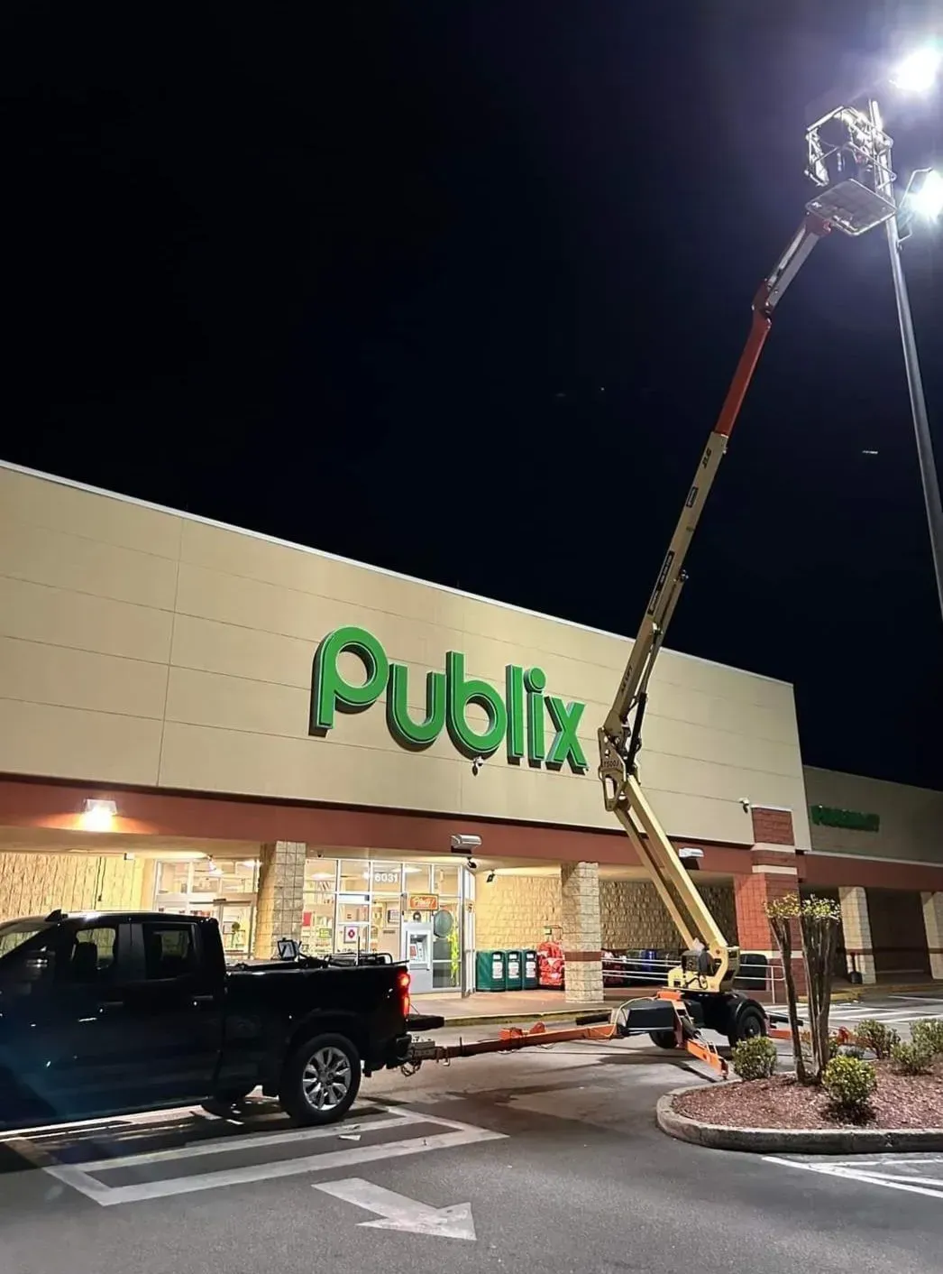 A truck is parked in front of a publix store at night.