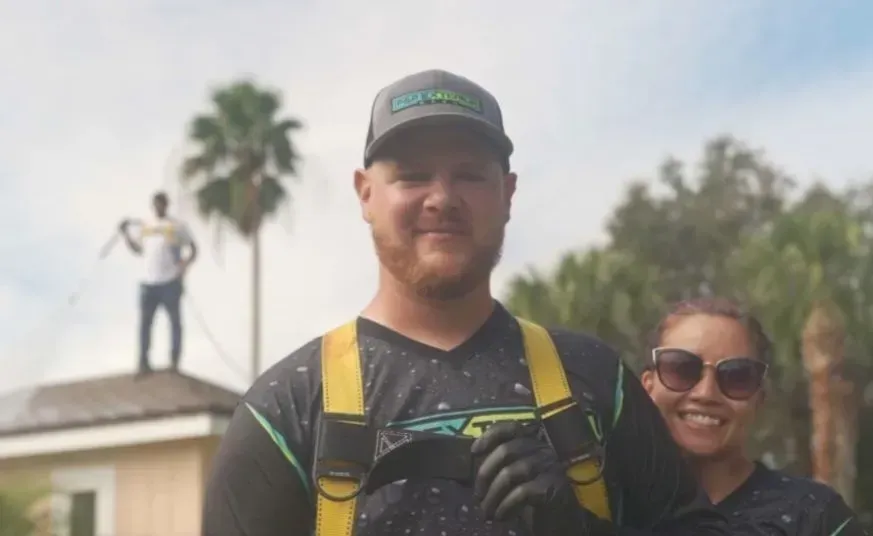 A man and a woman are standing next to each other on a roof.