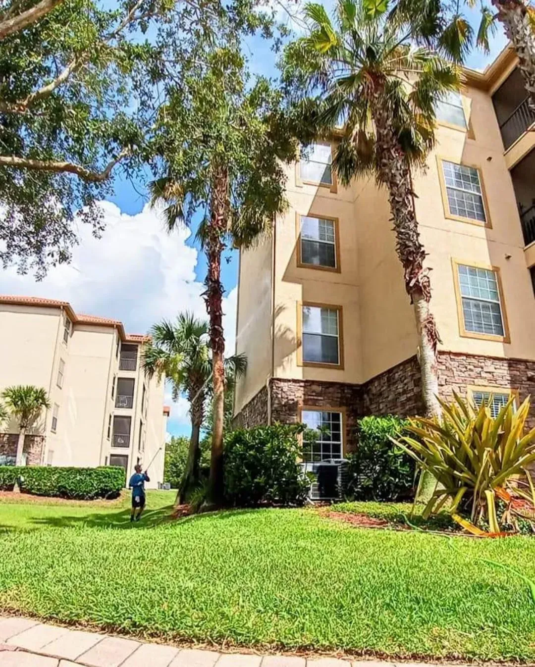 A man is standing in front of a large apartment building.