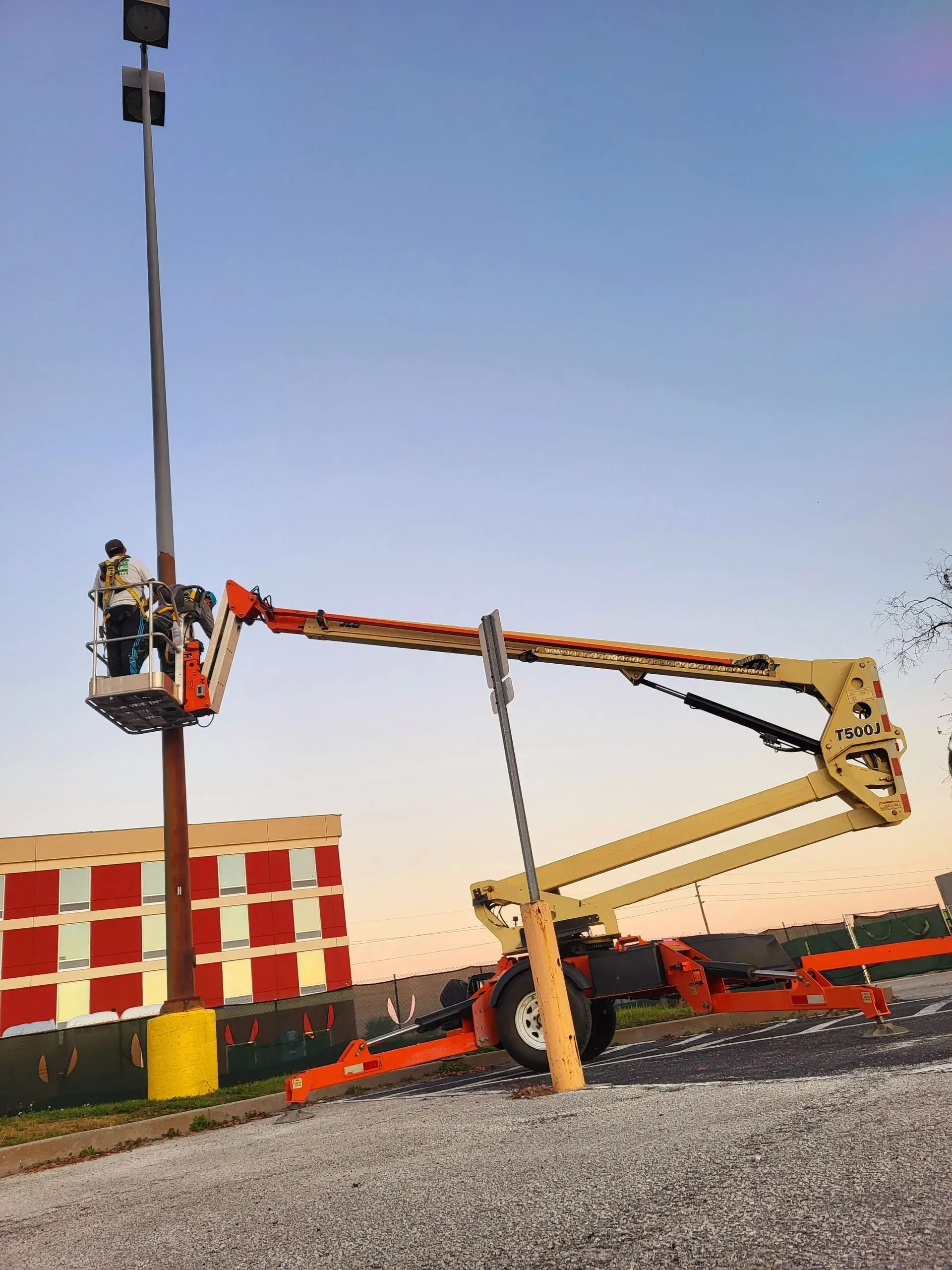A man in a bucket is working on a street light