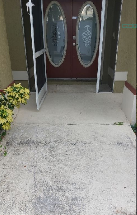 The front door of a house is open and has a screen door.