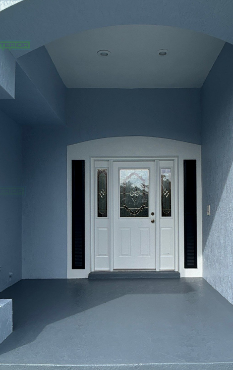 A blue house with a white door and black windows
