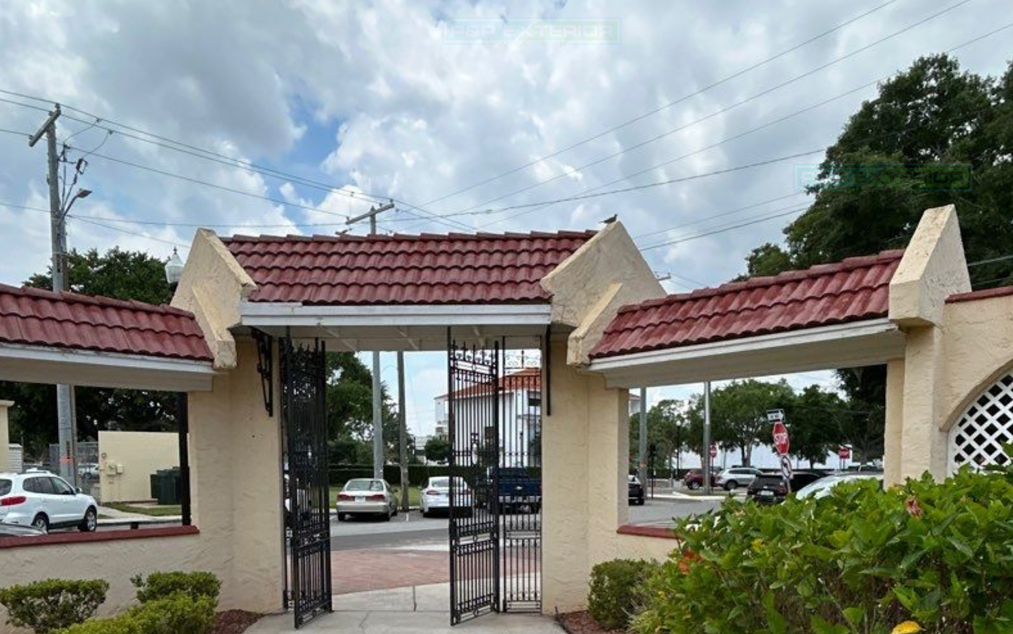 A building with a red tile roof and a gate in front of it.
