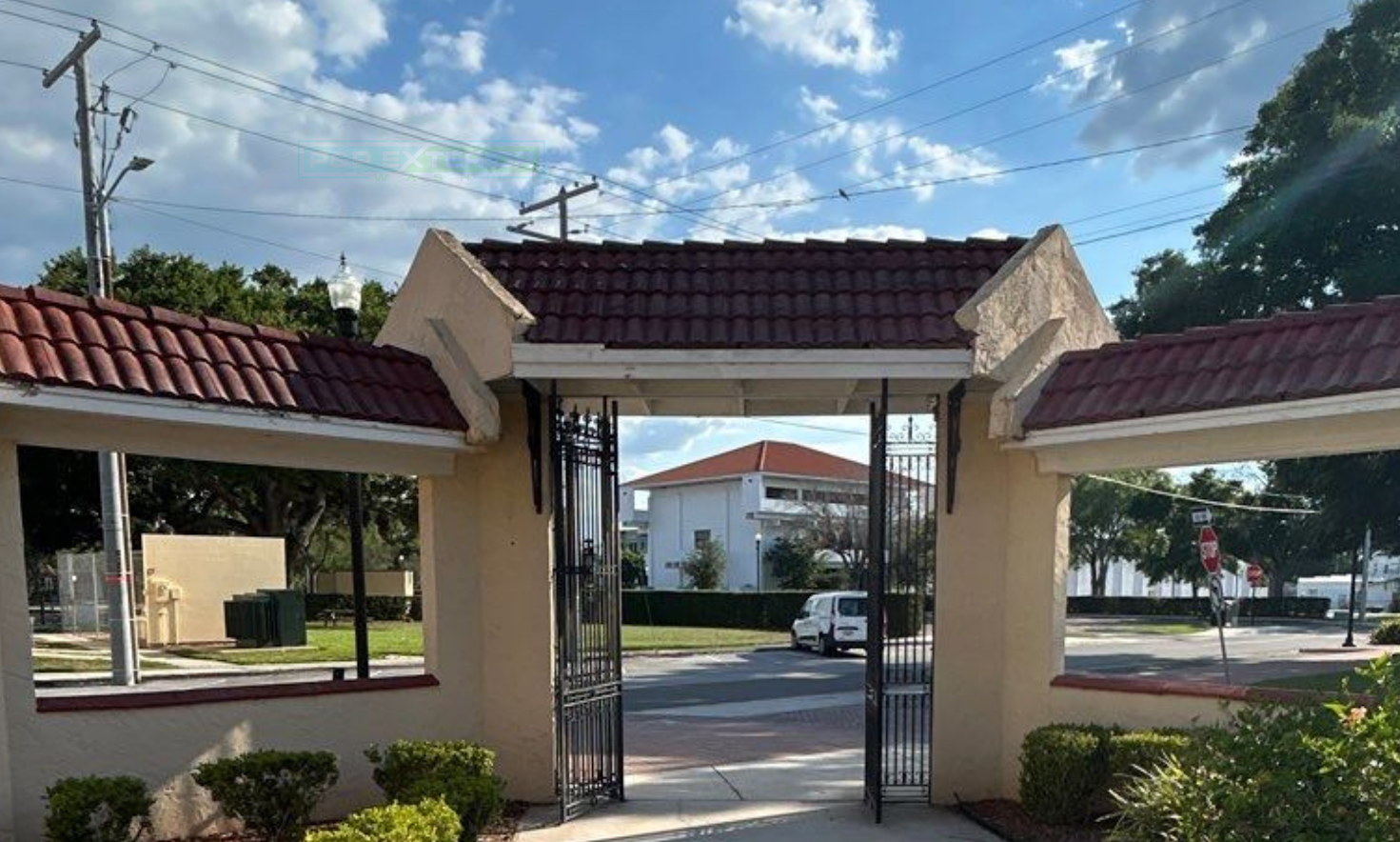 A gated entrance to a building with a red tile roof