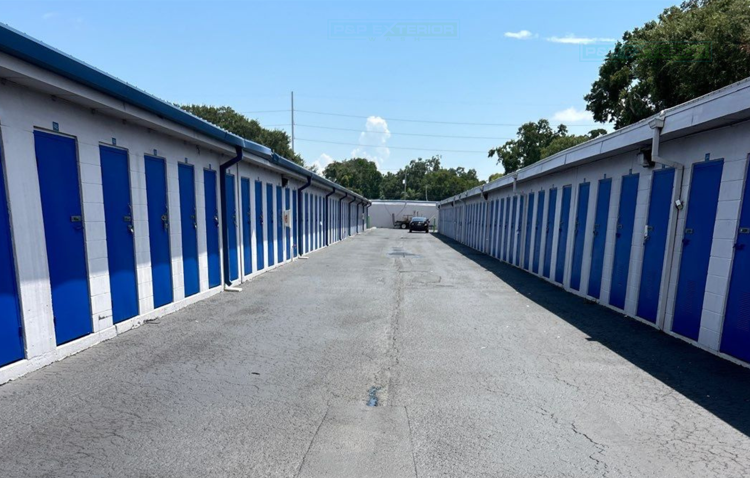 A row of blue and white striped buildings are lined up in a parking lot.