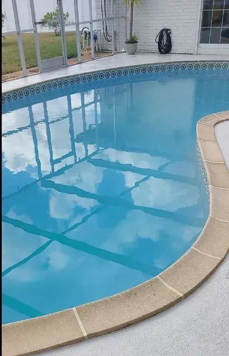 A large swimming pool with a reflection of clouds in the water.