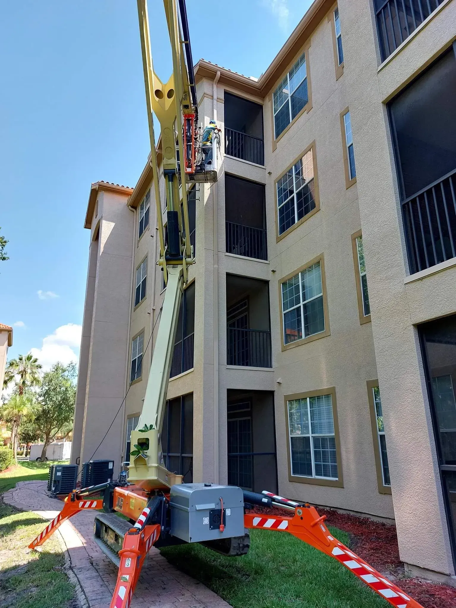 A crane is sitting in front of a large building.