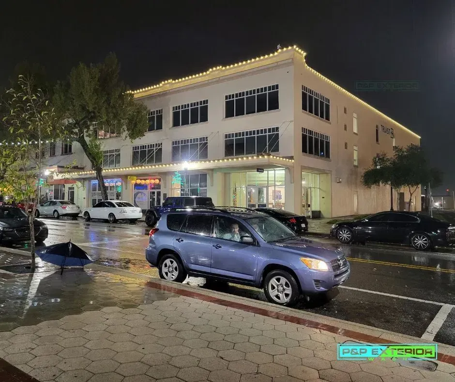 A blue suv is parked in front of a building at night.