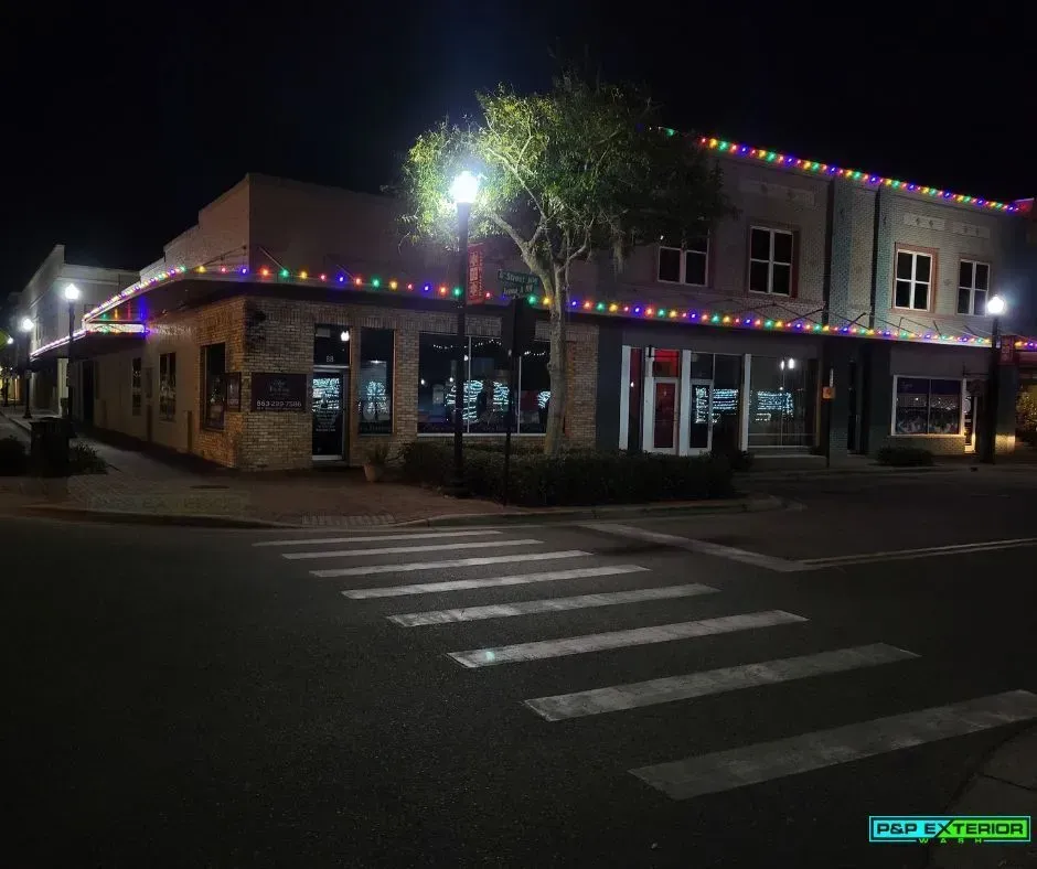 A building with christmas lights on it is lit up at night.