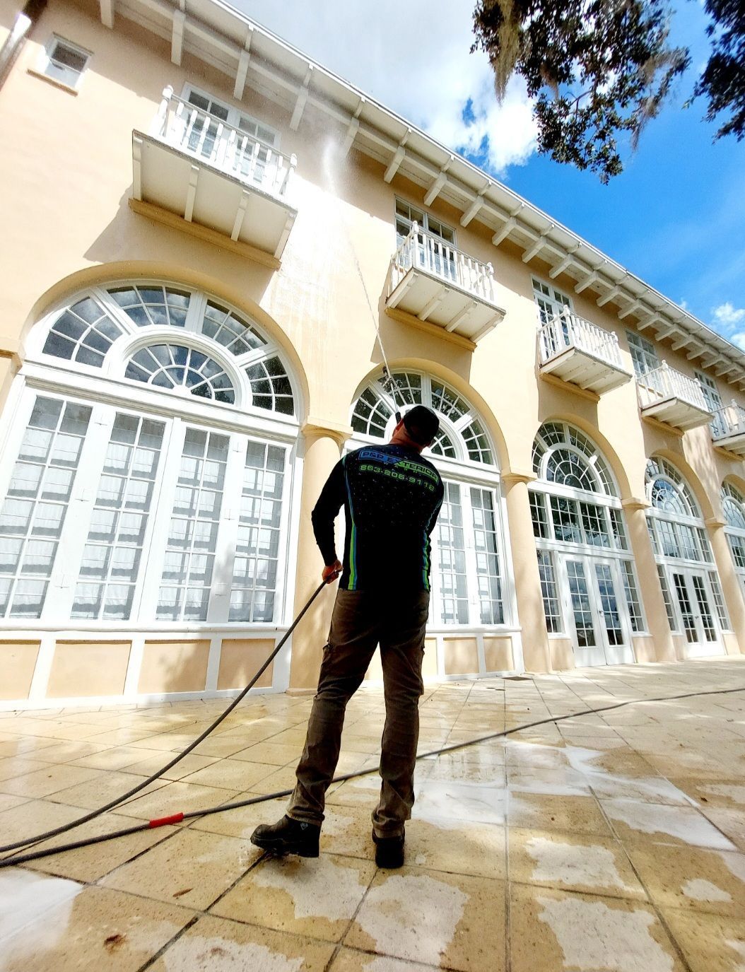 A man in a blue shirt is cleaning a garage door