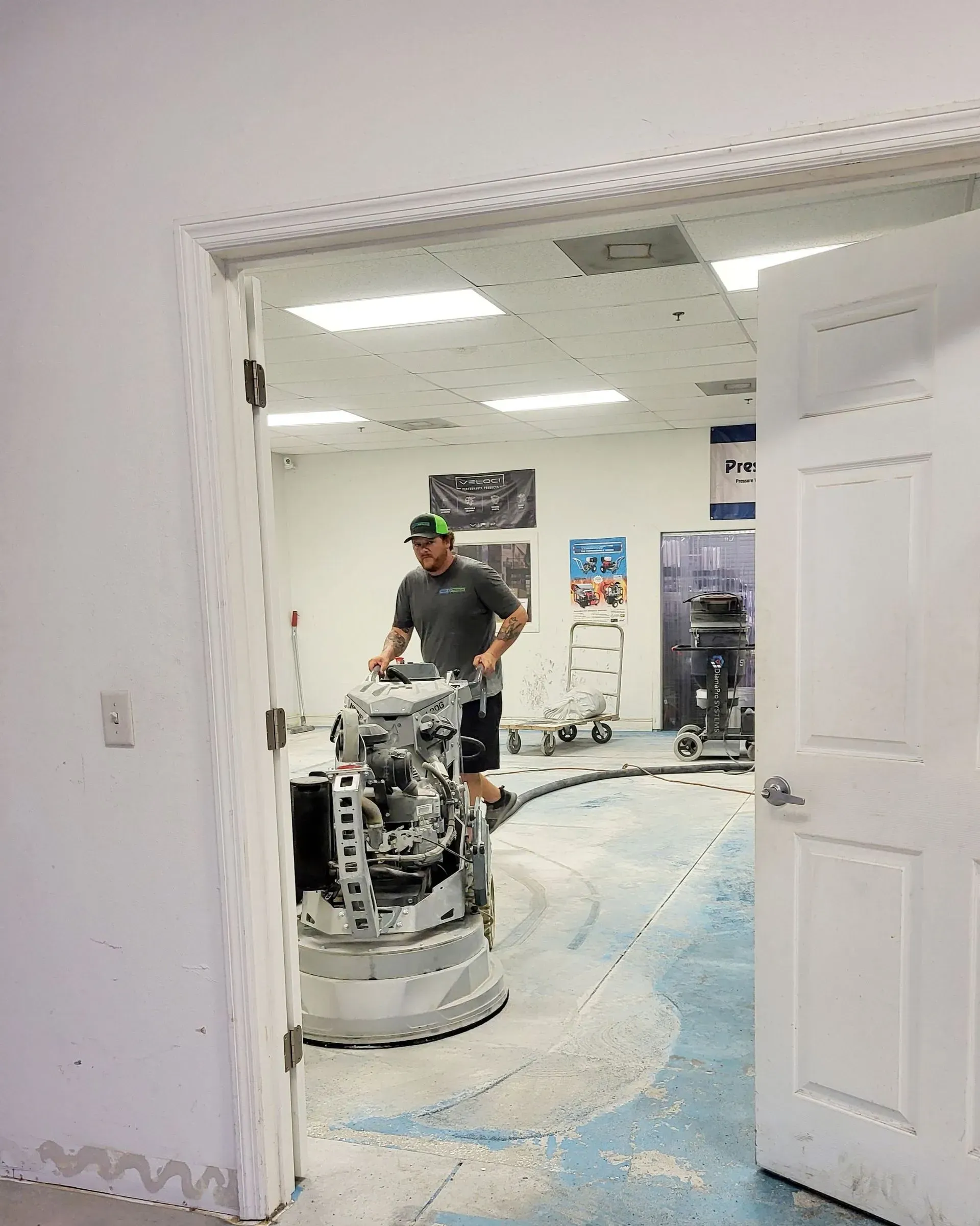 A man is using a machine to polish the floor in a room.