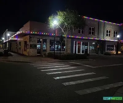 A building with christmas lights on it is lit up at night.