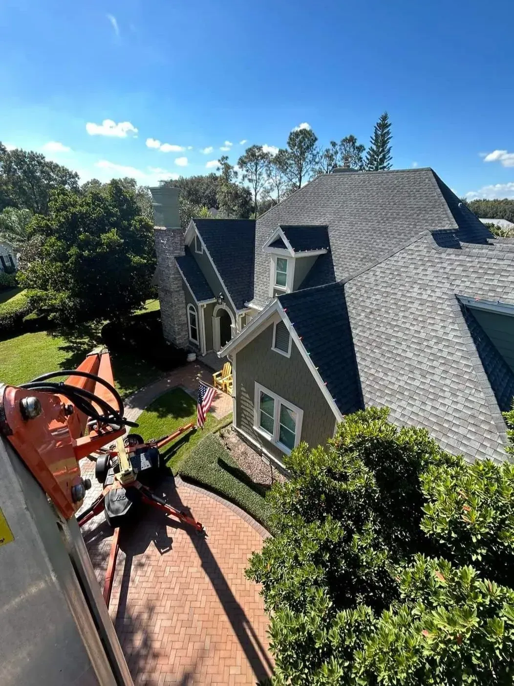 An aerial view of a house with a crane in front of it.