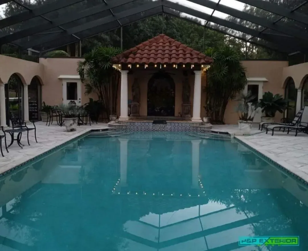 A large swimming pool with a gazebo in the background