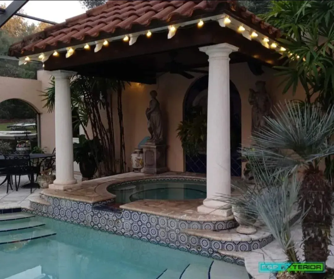 A swimming pool with a gazebo and pillars surrounding it