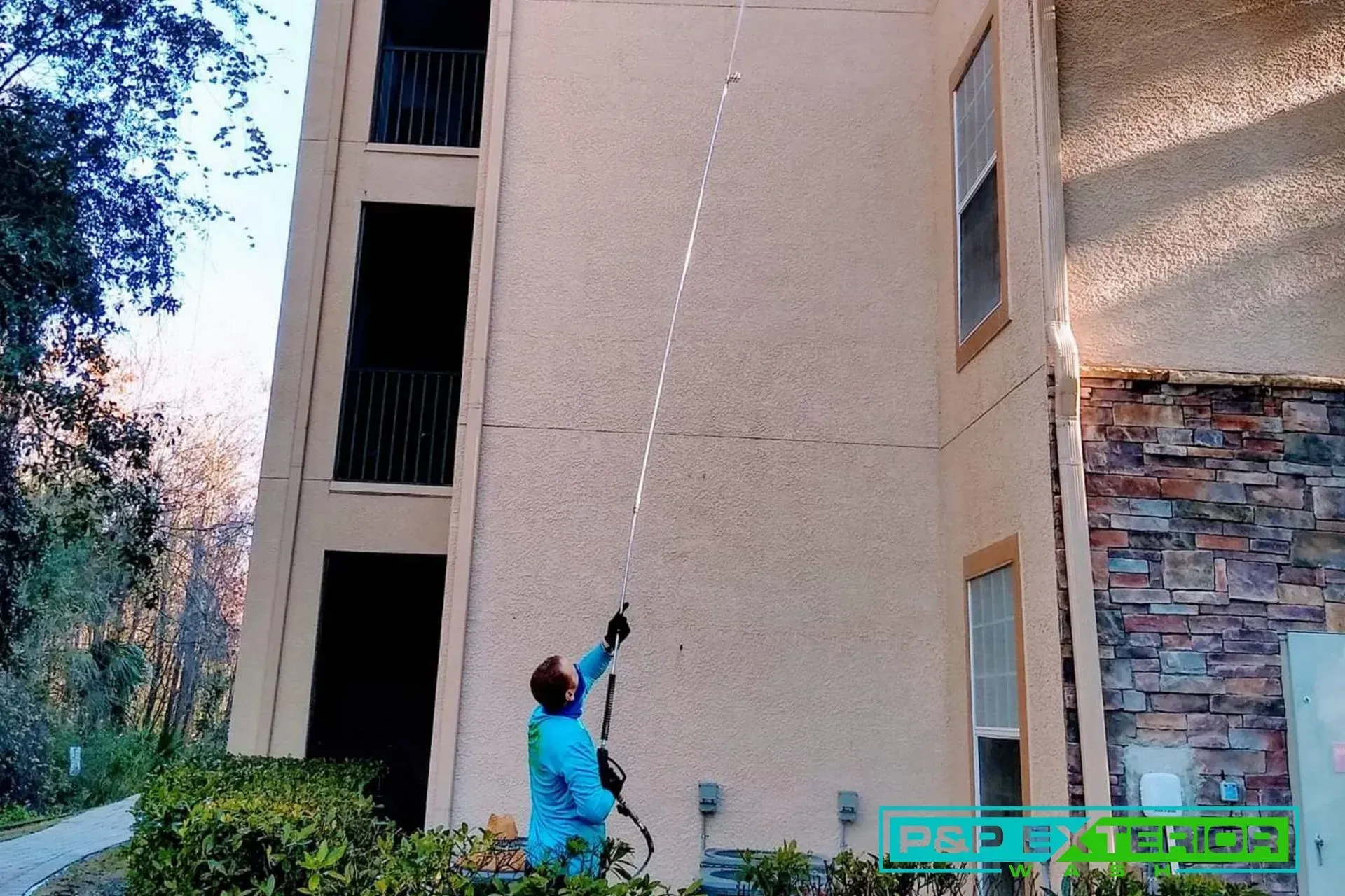 A man is spraying a building with a hose