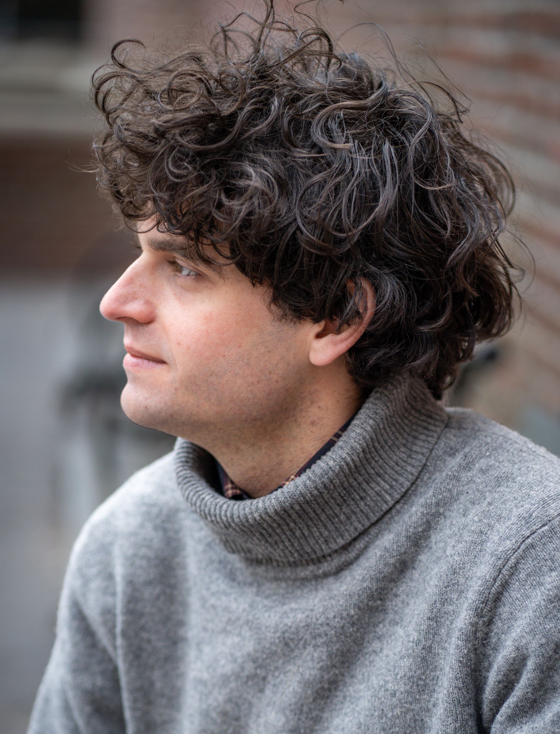 Riley Scott looking off camera in a grey sweater