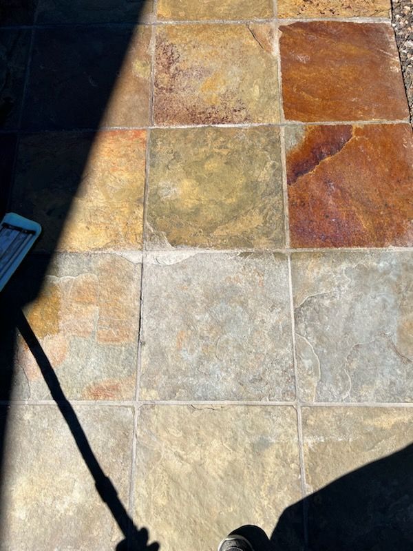 Square flagstone patio with shades of brown, tan, and gray, in sunlight.