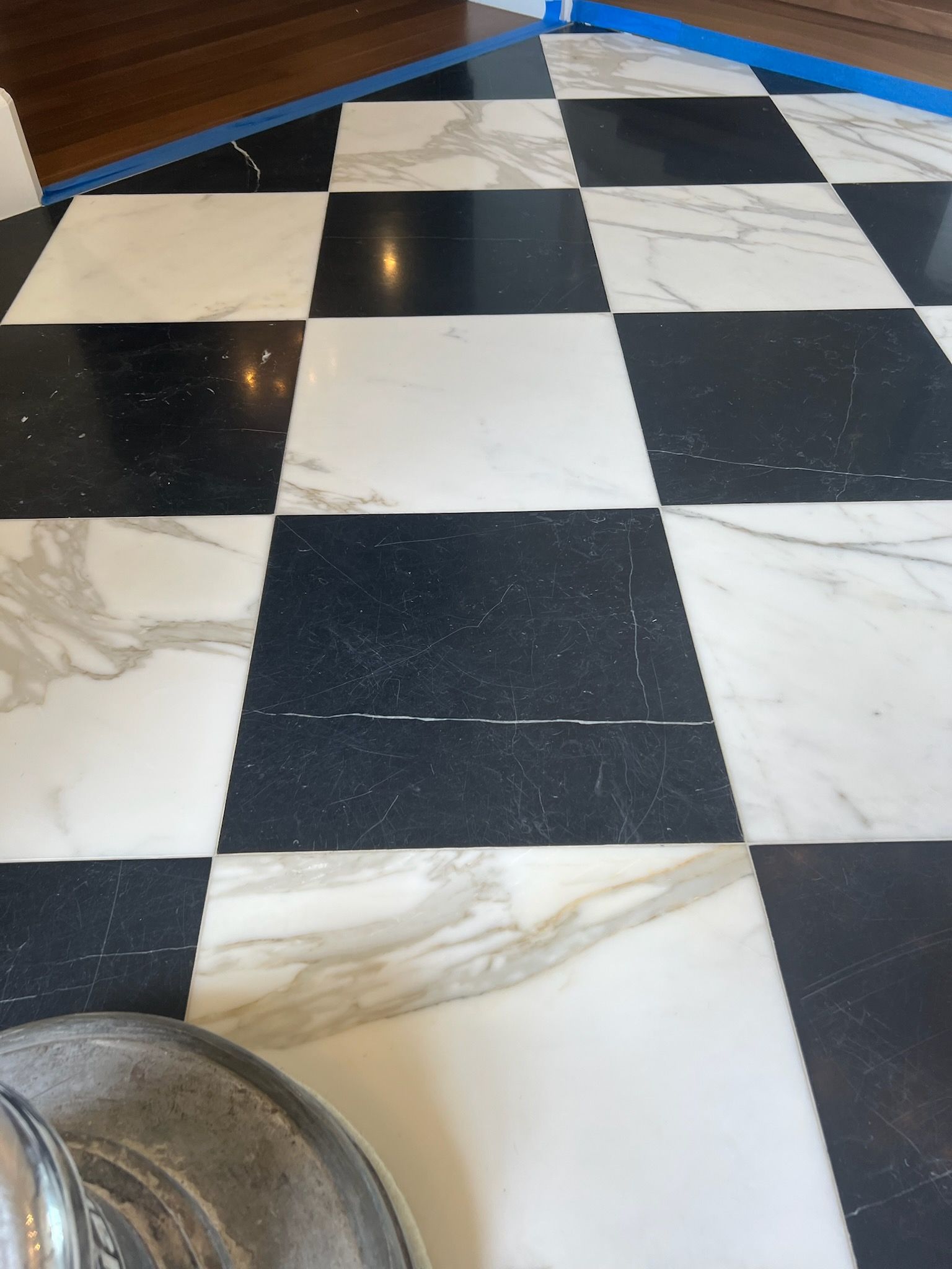 Checkerboard marble floor with black and white tiles.