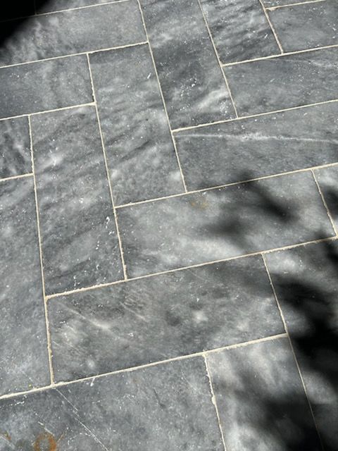 Gray stone tiles laid in a brick pattern, with visible veining and light grout lines.
