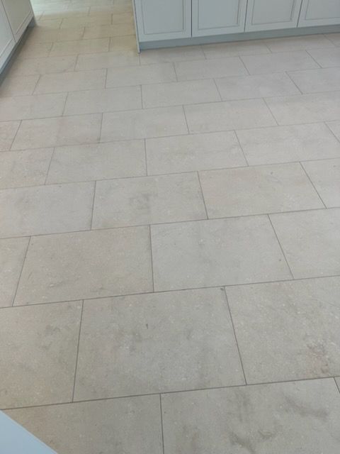 Beige rectangular tiles on a kitchen floor.