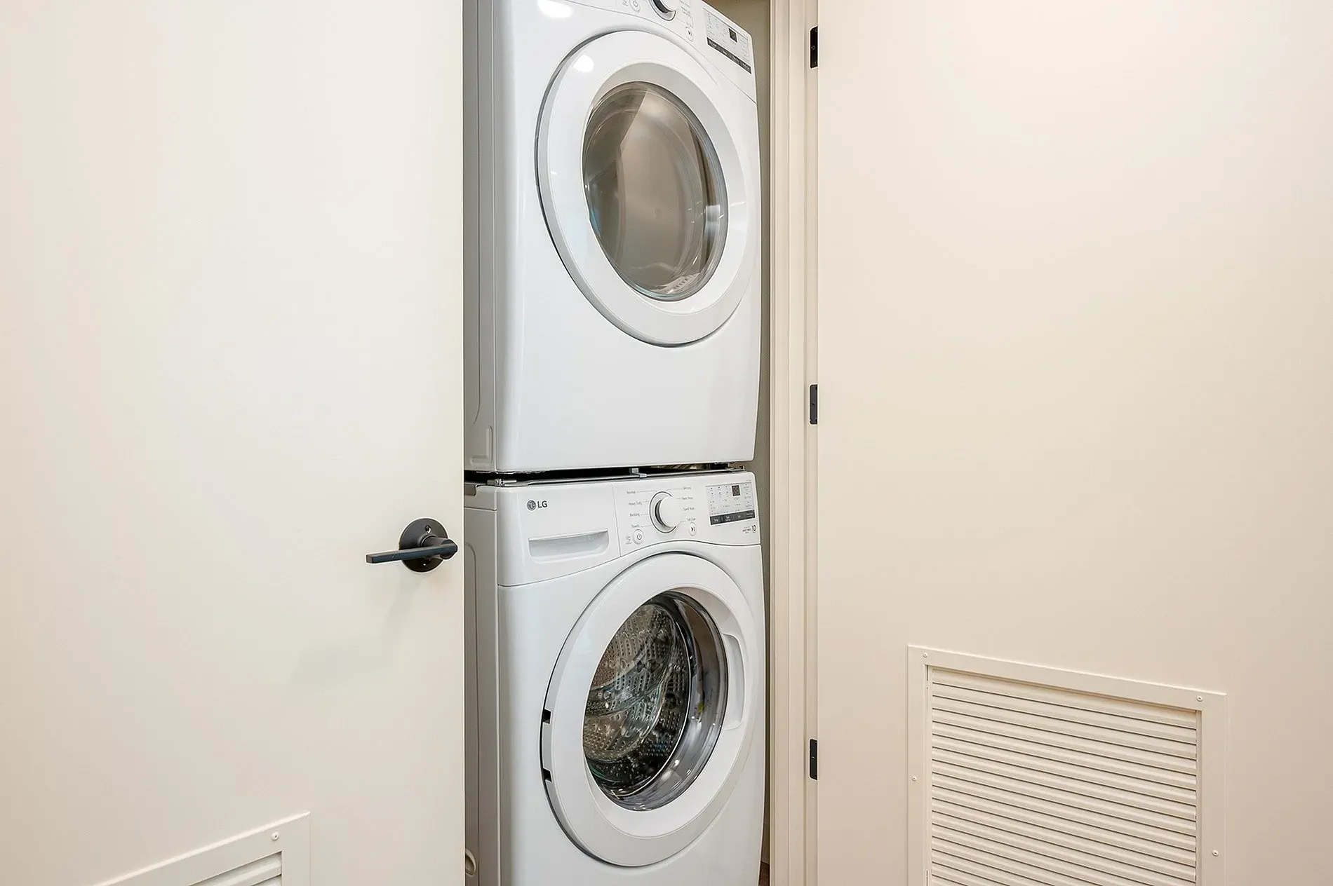 Stacked white LG washer and dryer in a closet.