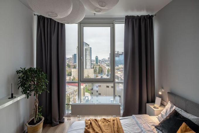 There is a Large Window in the Bedroom With a View of the City — Catrina's Custom Curtains & Blinds in Toukley, NSW