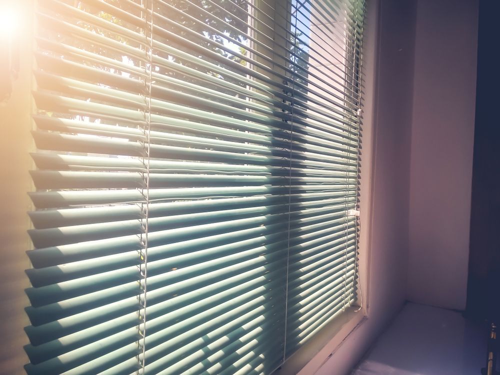 The Sun Is Shining Through The Blinds Of A Window — Catrina's Custom Curtains & Blinds in Wyee, NSW