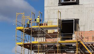 Un groupe d'ouvriers du bâtiment travaille sur un bâtiment en construction.