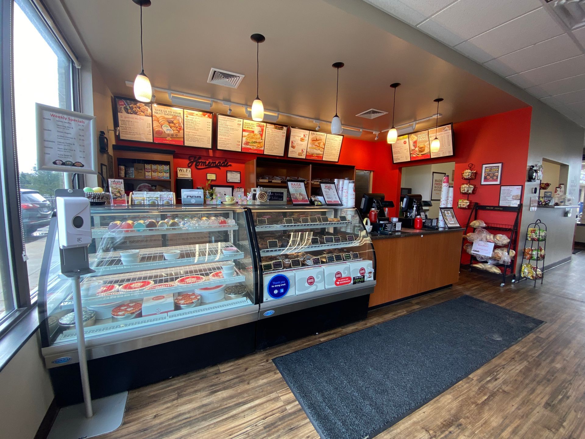 The inside of a bakery with a display case and a counter.