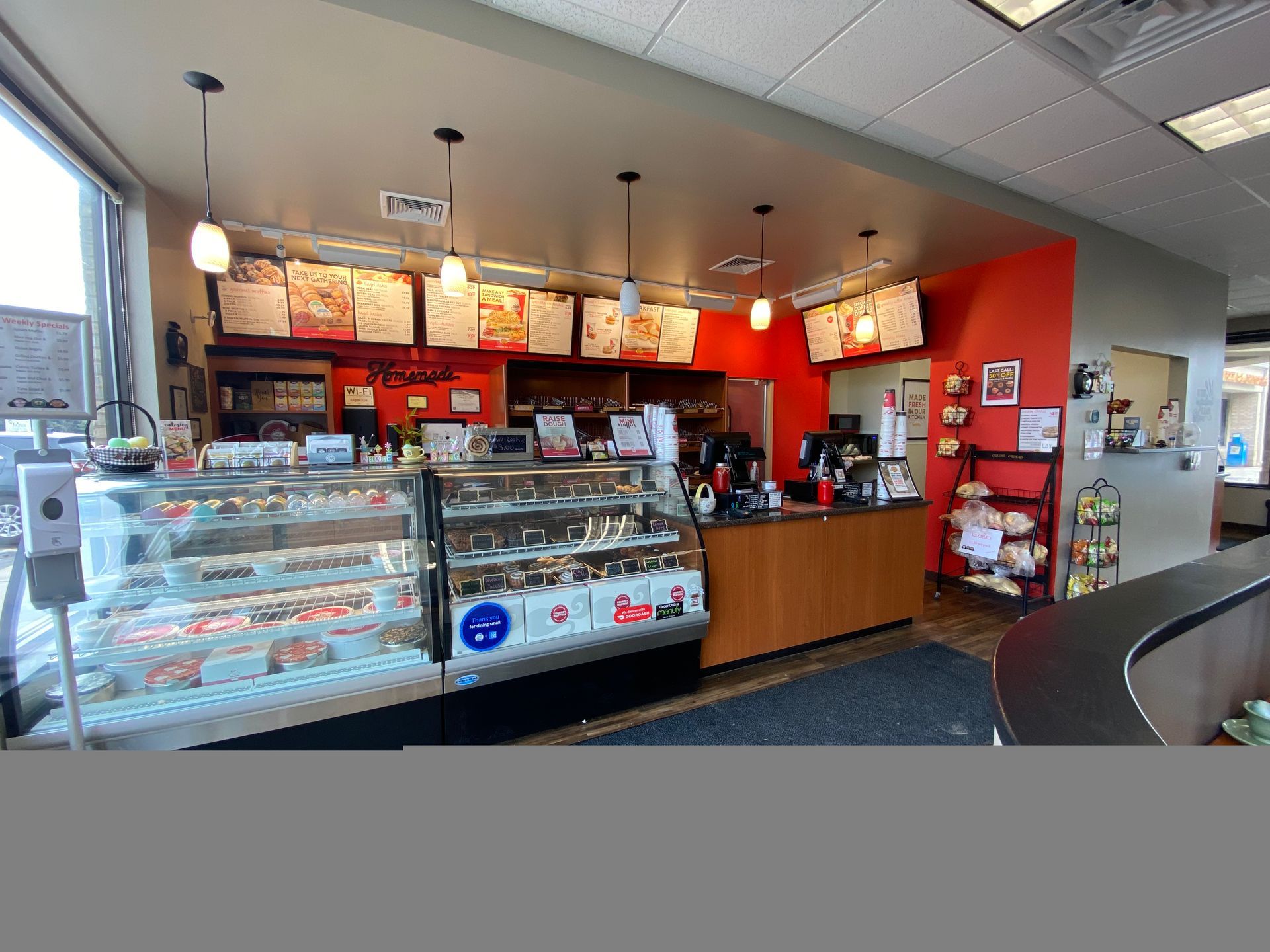 The inside of a restaurant with a display case and a counter.