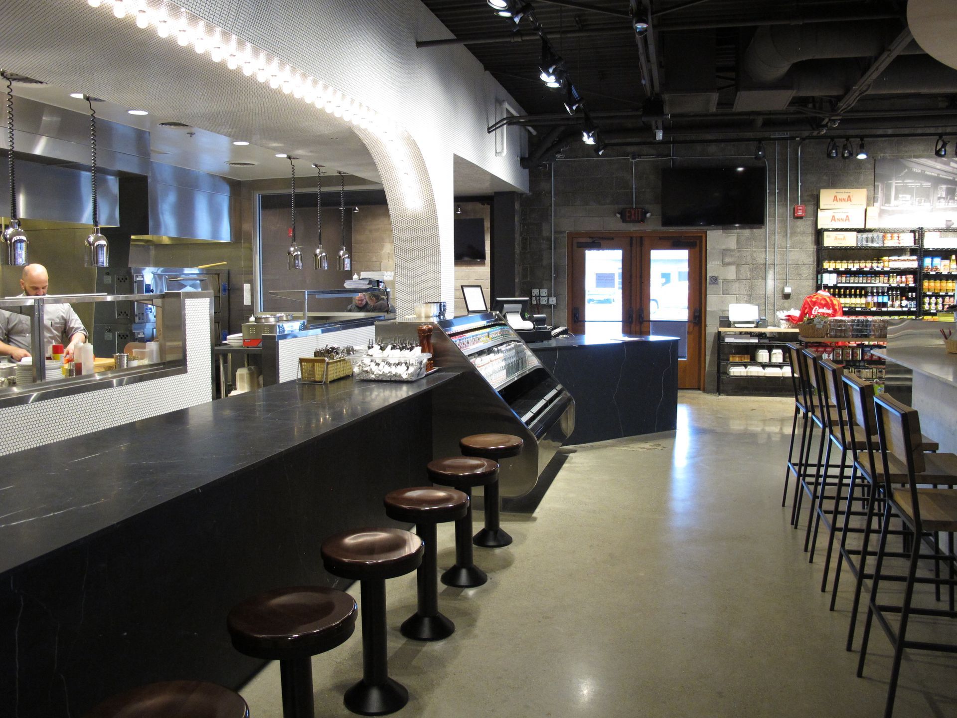 A restaurant with a long counter and stools