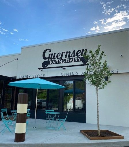 Guernsey farms dairy is a dairy store with tables and chairs outside.