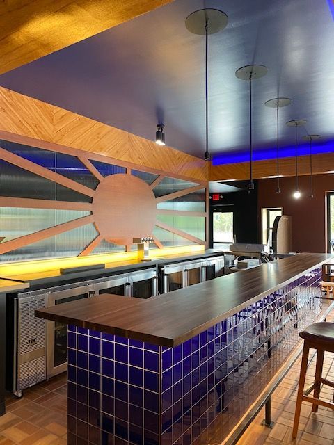A kitchen with blue tiles and a wooden counter top