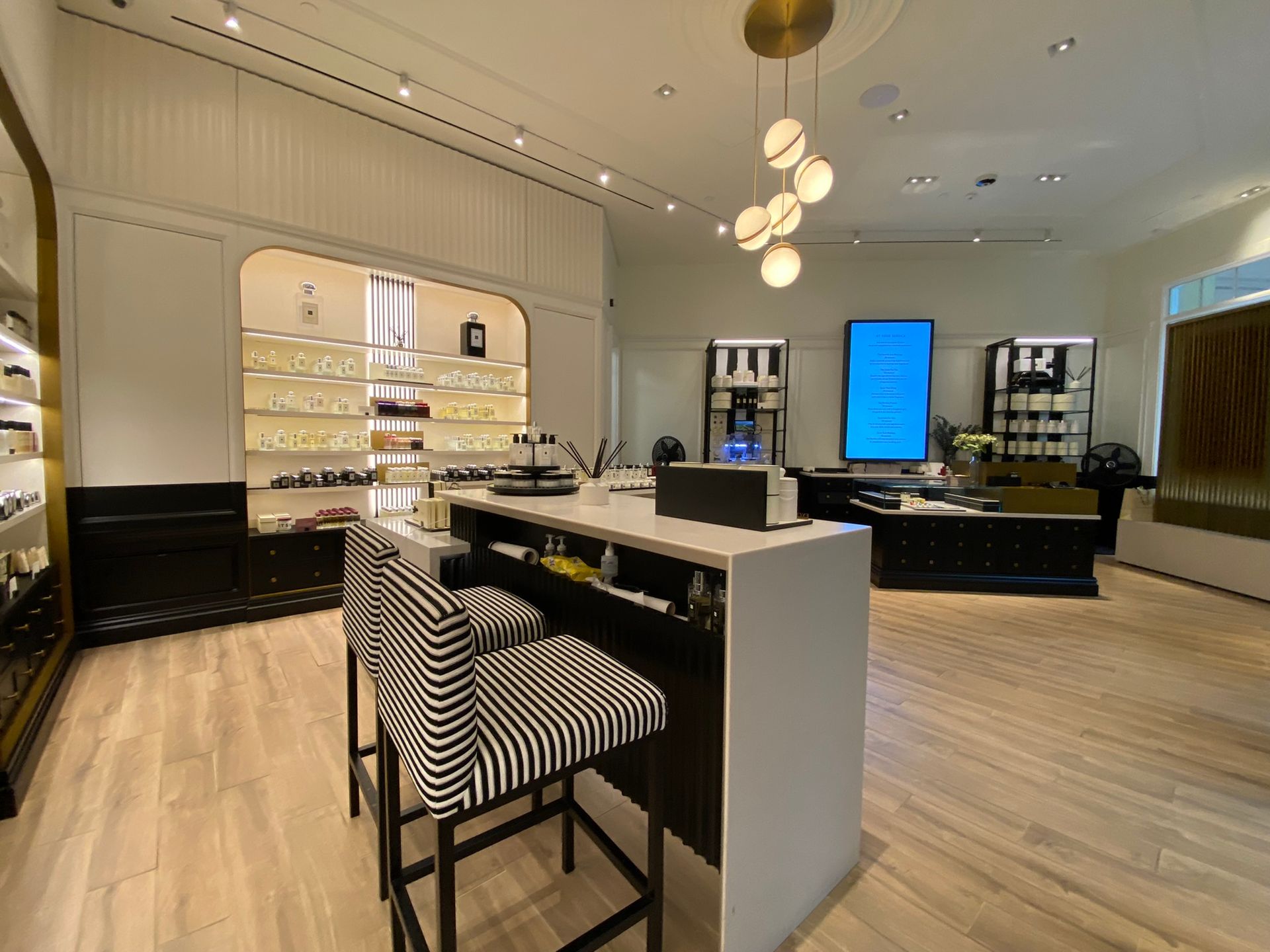 There is a bar in the middle of the room with striped chairs.