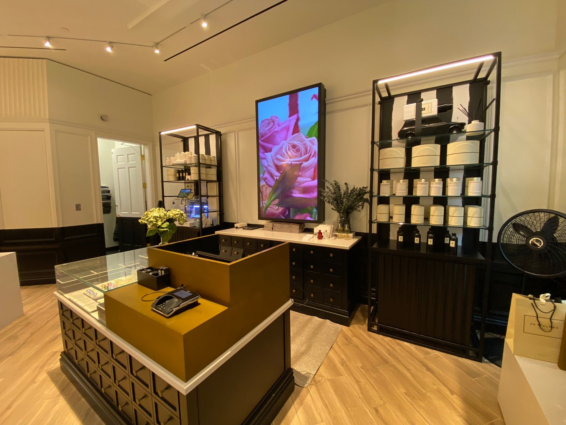 A room with a lot of shelves and a large screen on the wall.