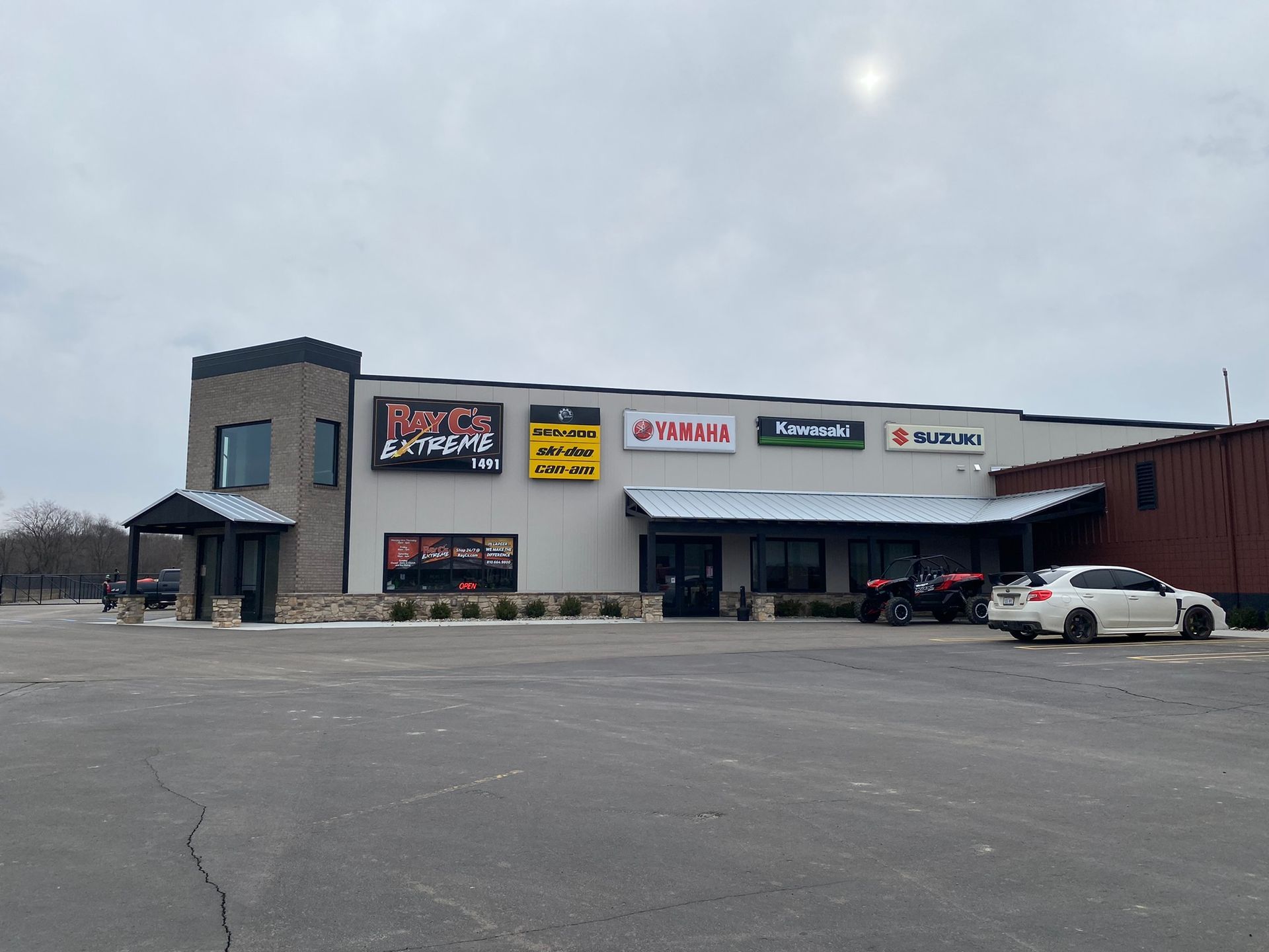 A large building with a lot of cars parked in front of it.