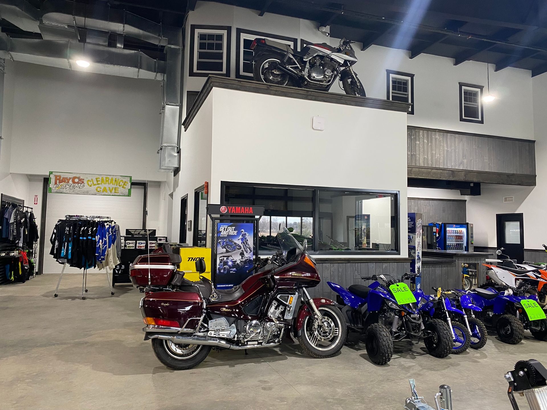 A row of motorcycles are parked in a warehouse.