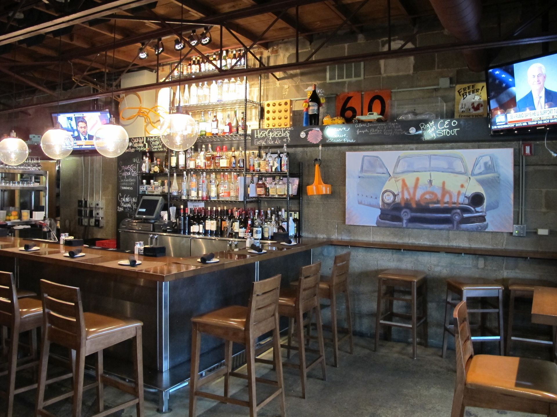 A bar in a restaurant with a picture of a car on the wall