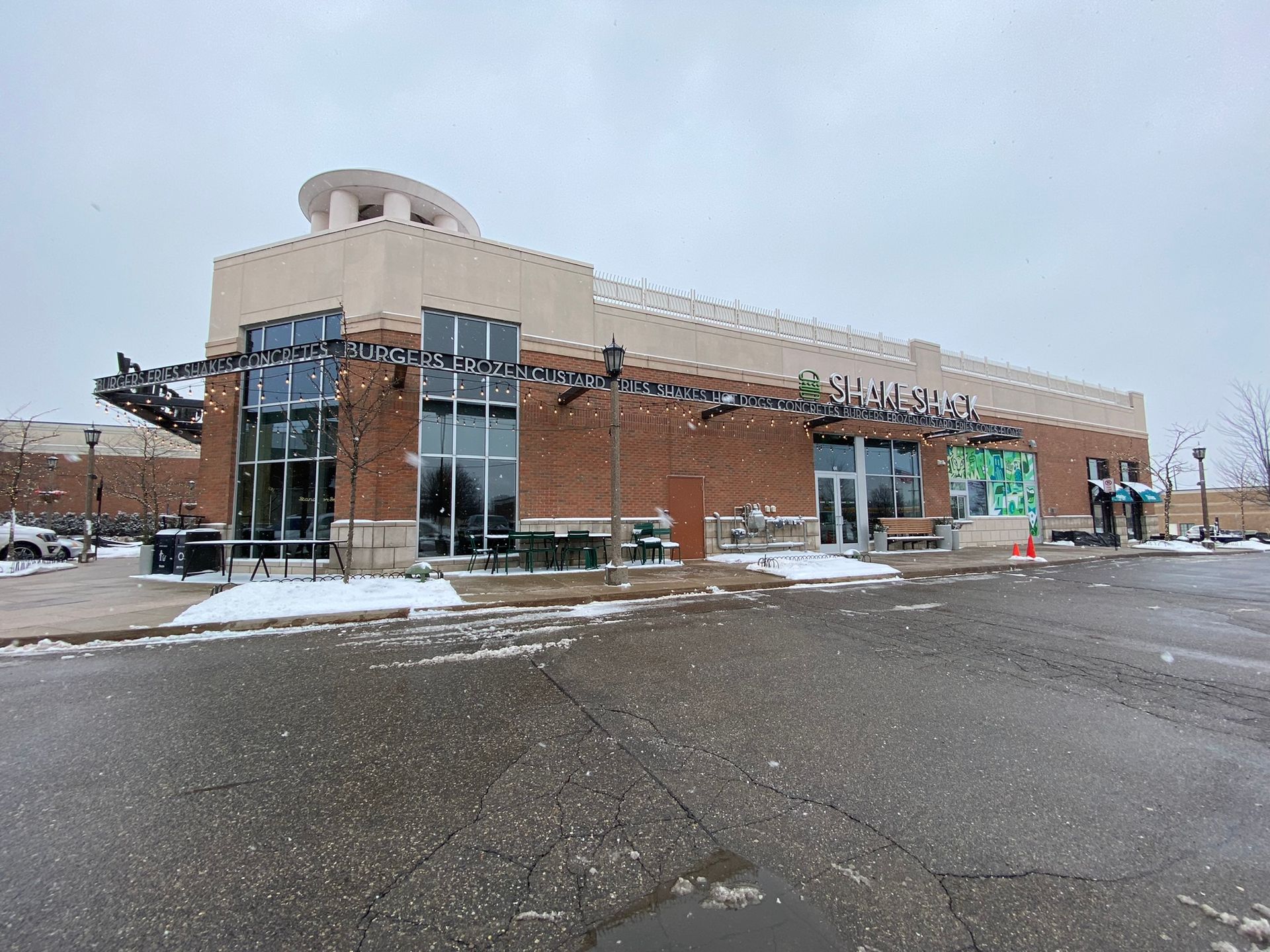 A large brick building with a lot of windows and a parking lot in front of it.