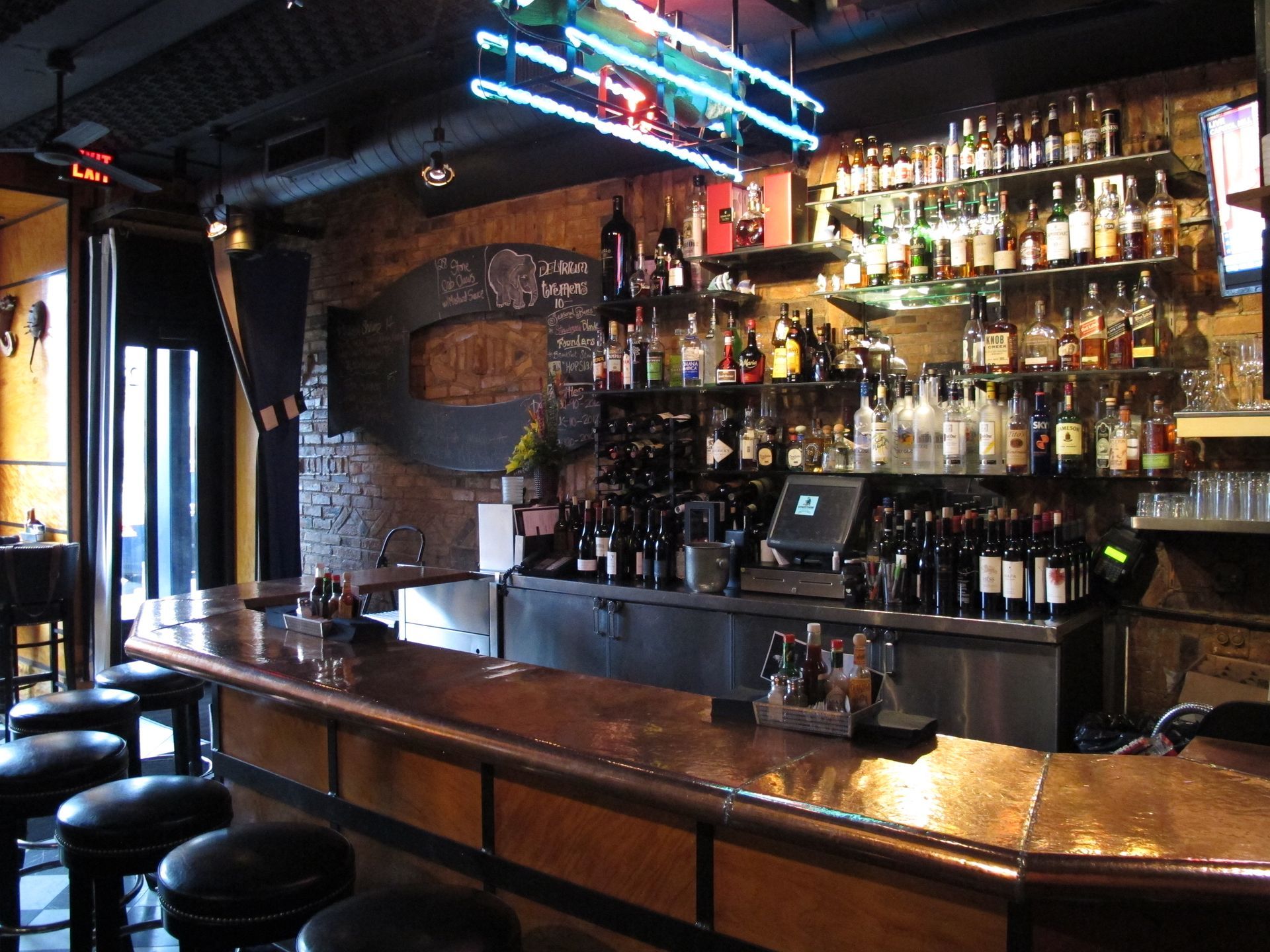 A bar with a lot of bottles on shelves