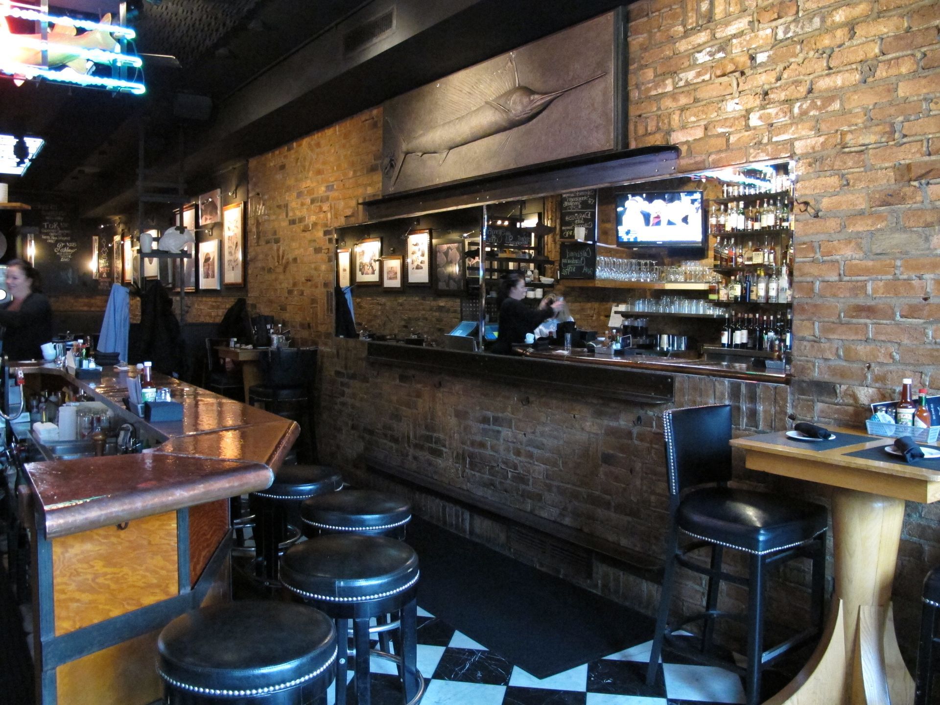 A restaurant with a checkered floor and a brick wall