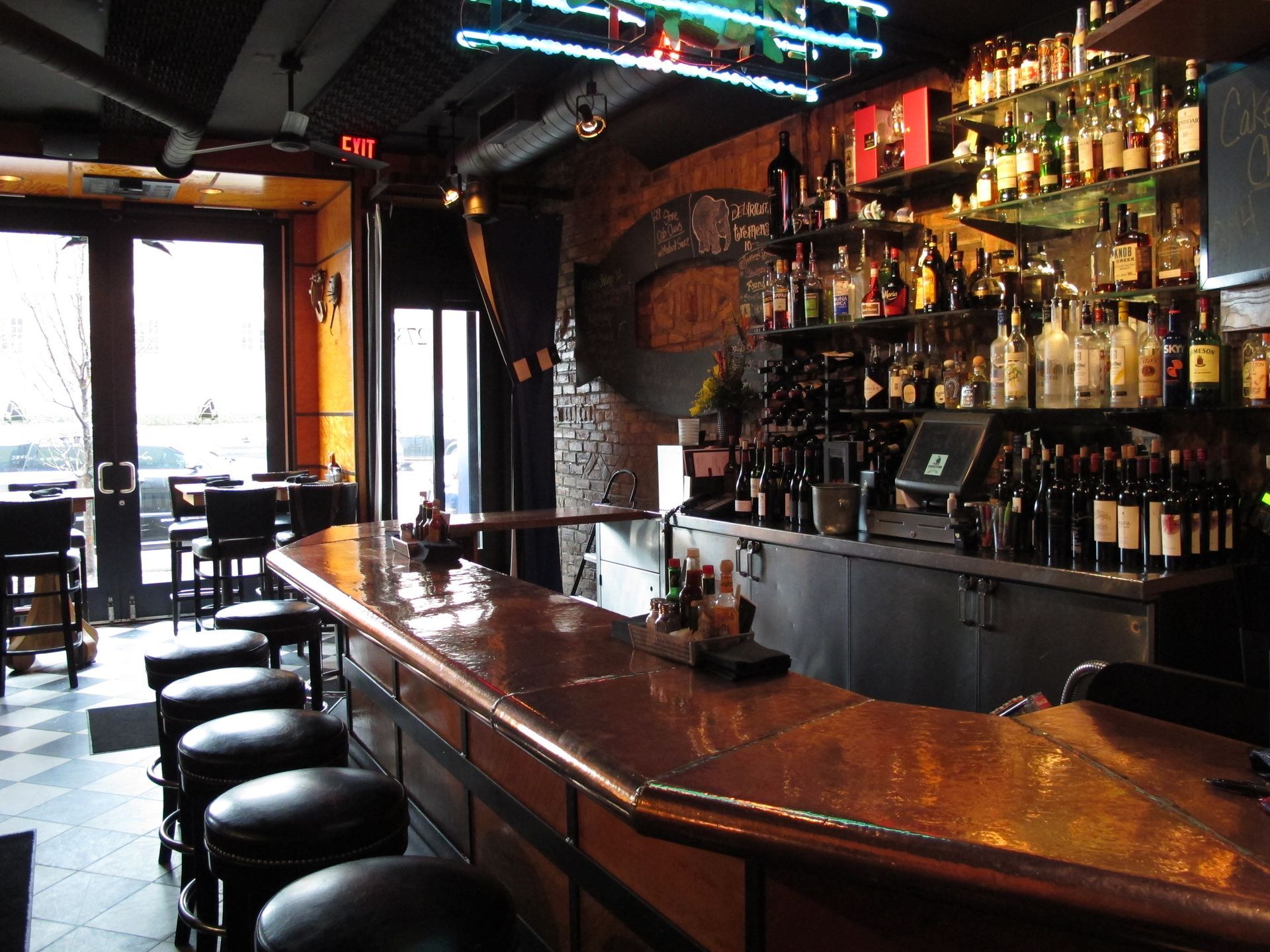 A bar with a neon sign that says exit on it