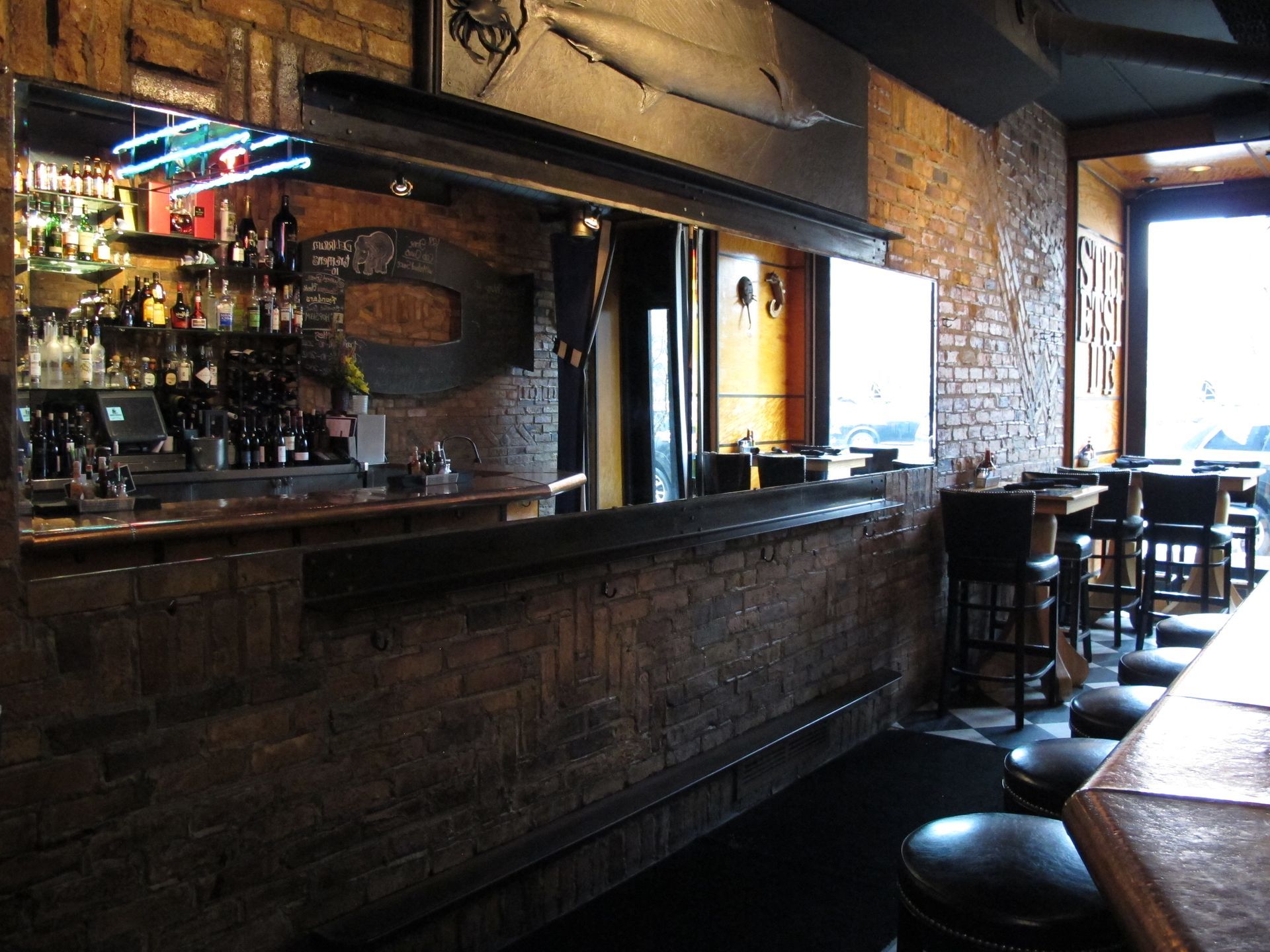 A bar in a restaurant with a fish on the wall